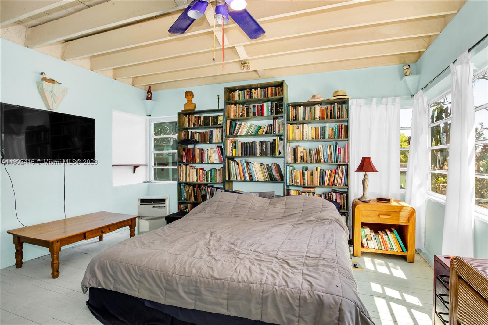 1541 Calais Drive Miami Beach, FL 33141 - Photo 17 of 33 a bedroom with a bed a books bucket with a desk and chair