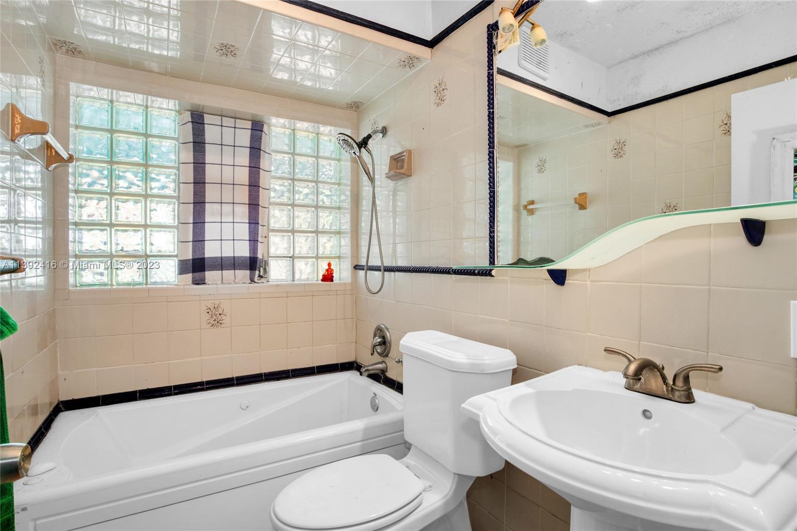 1541 Calais Drive Miami Beach, FL 33141 - Photo 18 of 33 a bathroom with a sink and a mirror