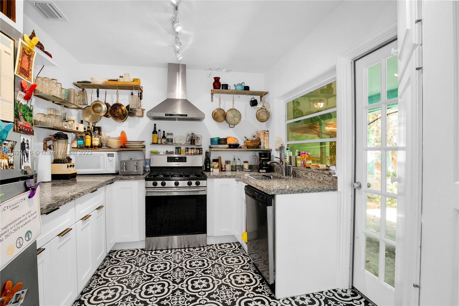 1541 Calais Drive Miami Beach, FL 33141 - Photo 10 of 33 a kitchen with stainless steel appliances granite countertop a sink stove and refrigerator