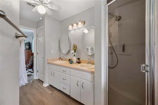 a bathroom with a double vanity sink mirror and shower
