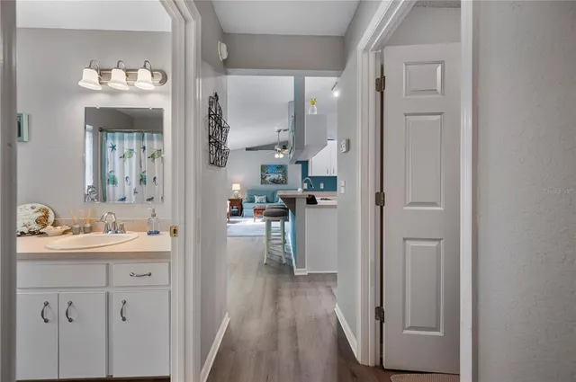 a view of a kitchen from the hallway with wooden floor
