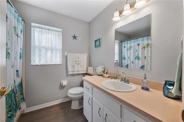 a bathroom with a granite countertop sink mirror vanity and toilet