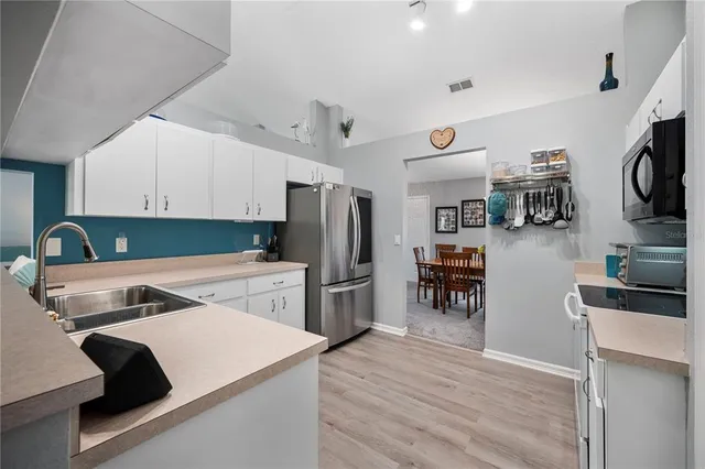 a kitchen with a refrigerator and a stove top oven