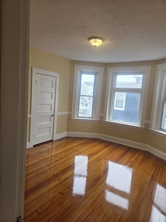 206 Harold Street, Unit 2 Boston, MA 02121 - Photo 3 of 7 a view of empty room with wooden floor and fan