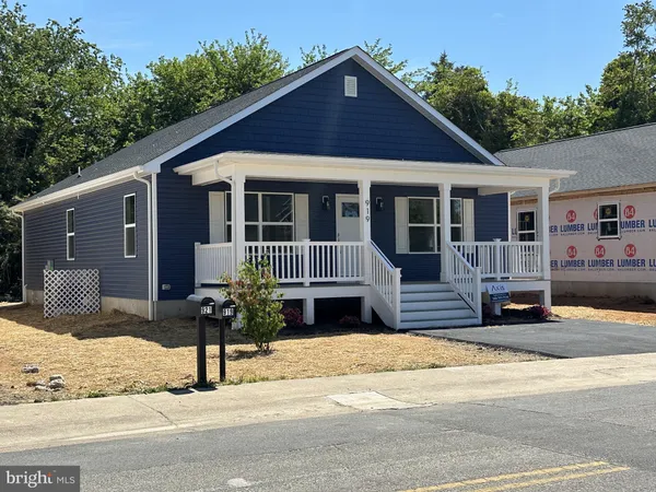 a front view of a house with a yard outdoor seating and garage
