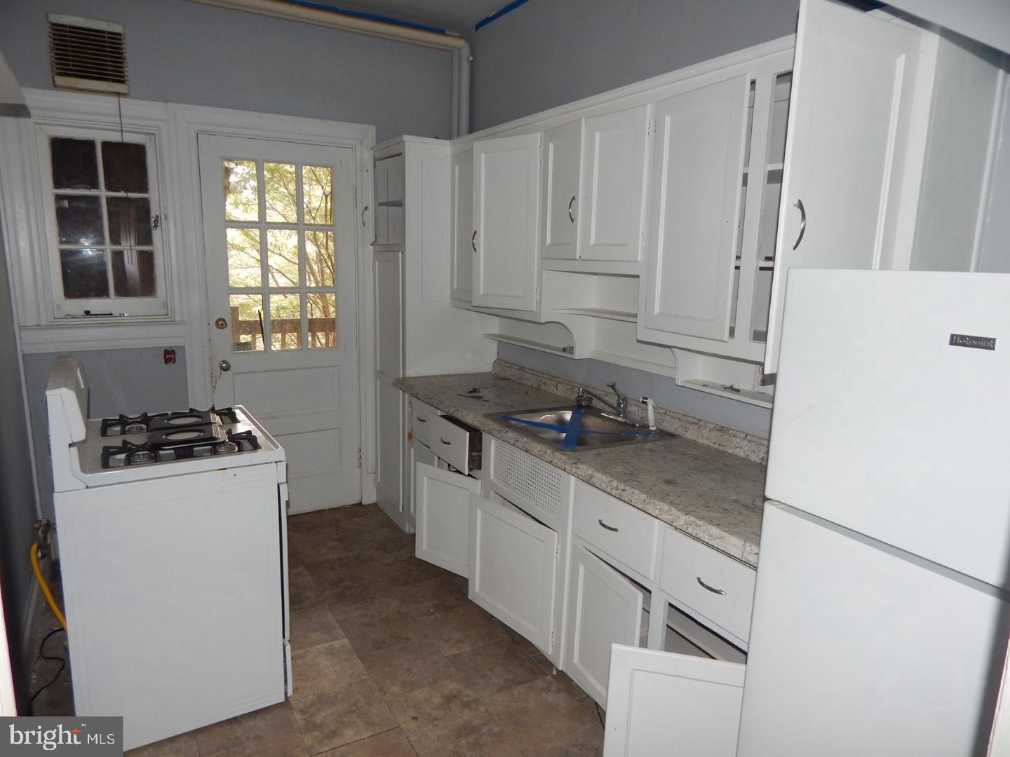 605 Upland Road Pikesville, MD 21208 - Photo 4 of 38 a kitchen with granite countertop white cabinets and white appliances