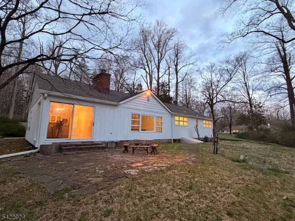a front view of house with yard and trees in the background