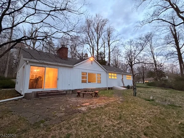 a front view of house with yard and trees around