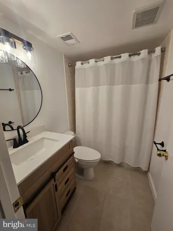 a bathroom with a sink vanity mirror and toilet