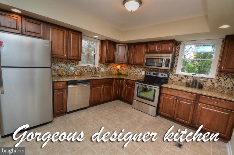 1302 Gransay Road Rosedale, MD 21237 - Photo 25 of 30 a kitchen with stainless steel appliances granite countertop a sink a stove a refrigerator with grey cabinets