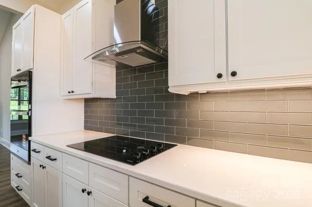 a kitchen with granite countertop white cabinets and white appliances