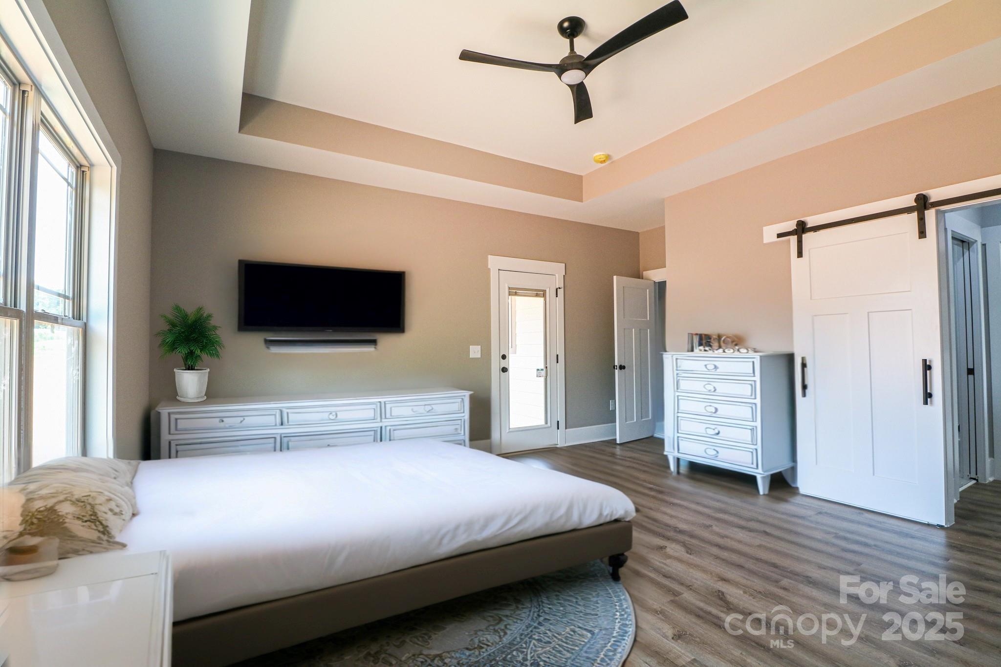 1070 Castle Ml Lane Salisbury, NC 28147 - Photo 15 of 38 a bedroom with a large bed a flat tv screen and a walk in closet