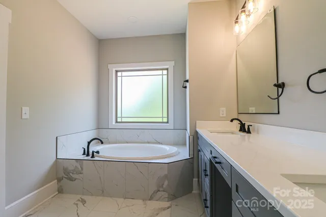 a bathroom with a tub sink and mirror