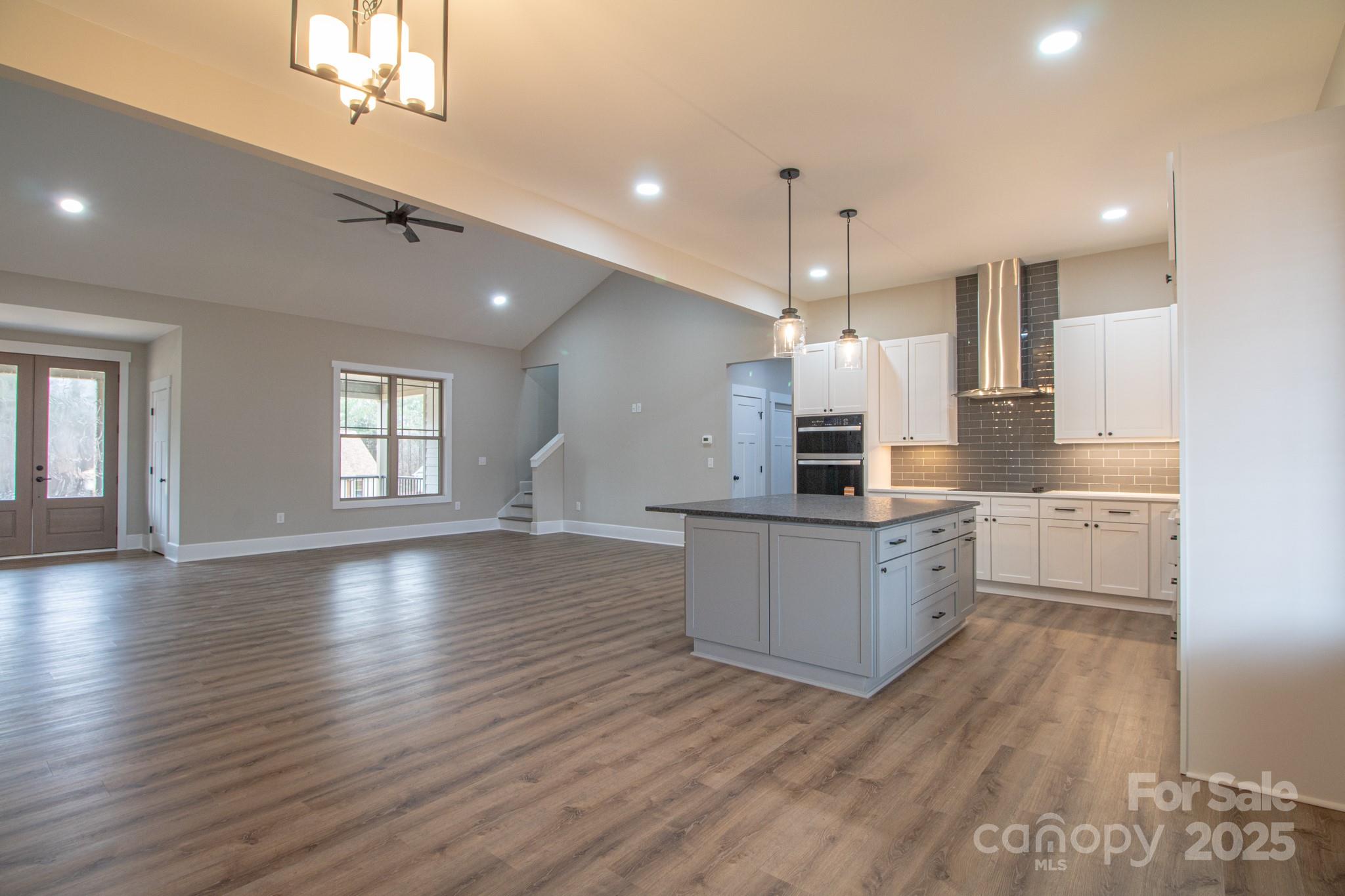1070 Castle Ml Lane Salisbury, NC 28147 - Photo 7 of 38 a kitchen with wooden floors and white cabinets