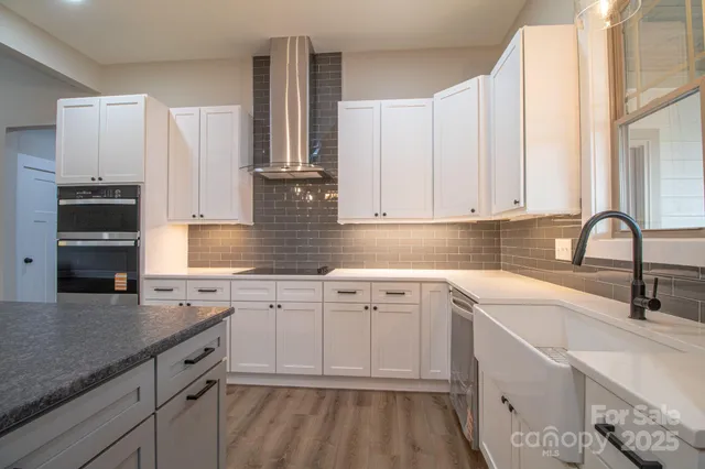 a kitchen with granite countertop white cabinets and white appliances