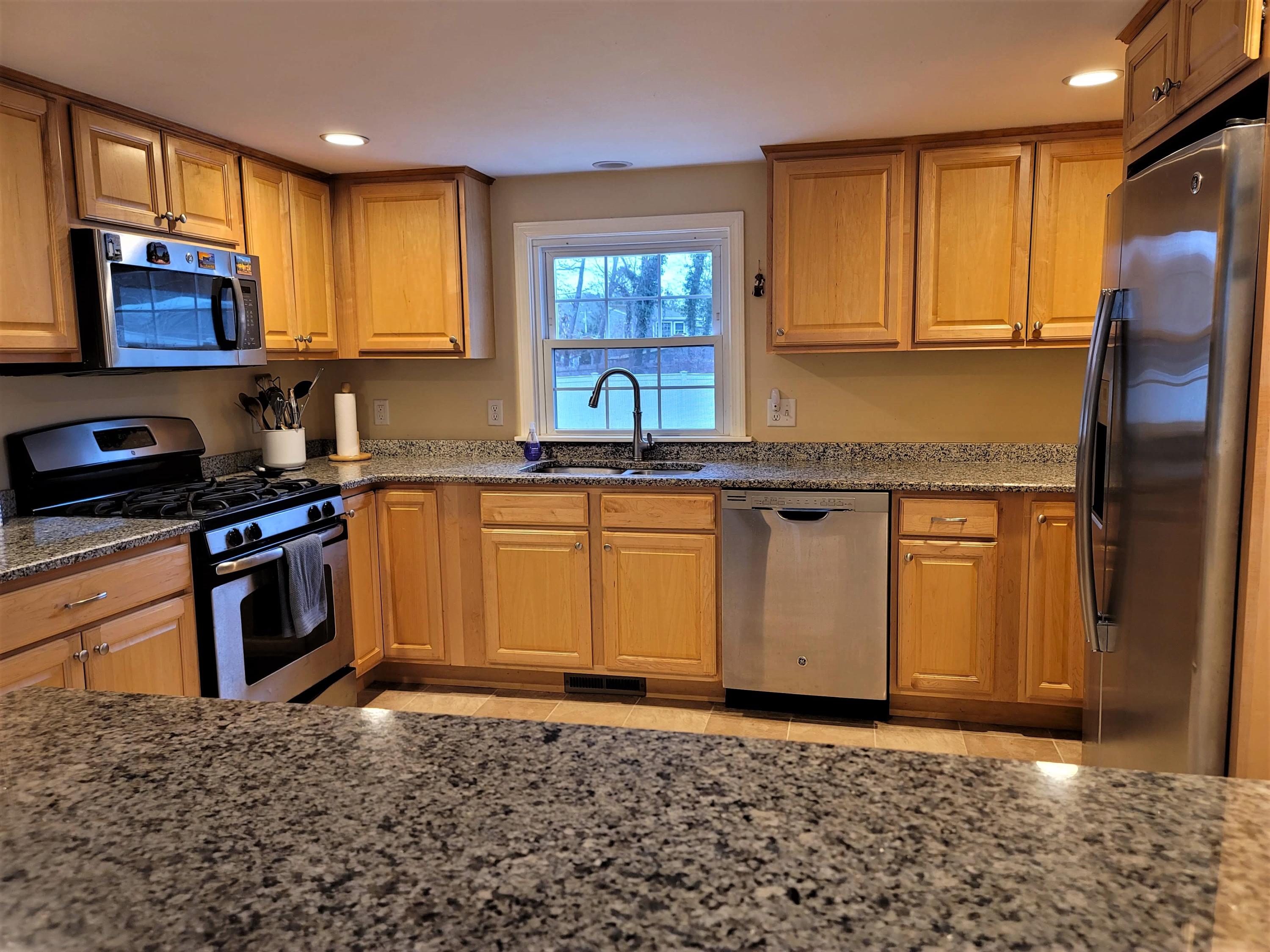 22 Monument Neck Road Bourne, MA 02532 - Photo 13 of 35 a kitchen with stainless steel appliances granite countertop a stove a sink and a microwave