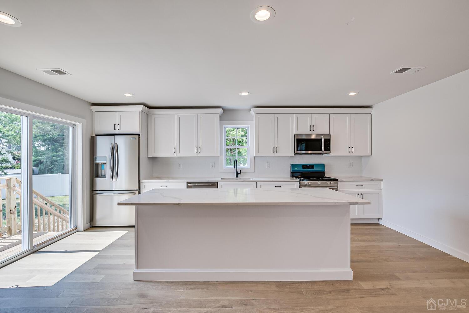21 Brian Road Edison, NJ 08817 - Photo 19 of 47 a large kitchen with stainless steel appliances a large center island and a window