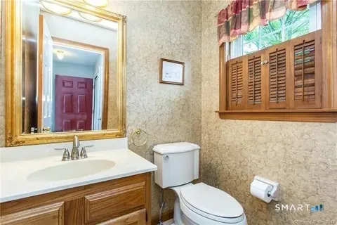 a bathroom with a granite countertop toilet sink and mirror