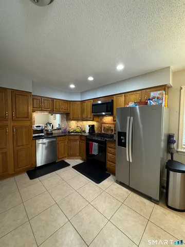 a kitchen with stainless steel appliances granite countertop a refrigerator and a stove