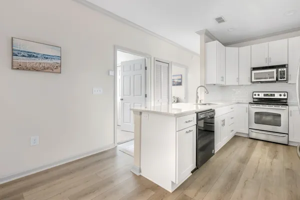 a kitchen with a stove a sink and a microwave