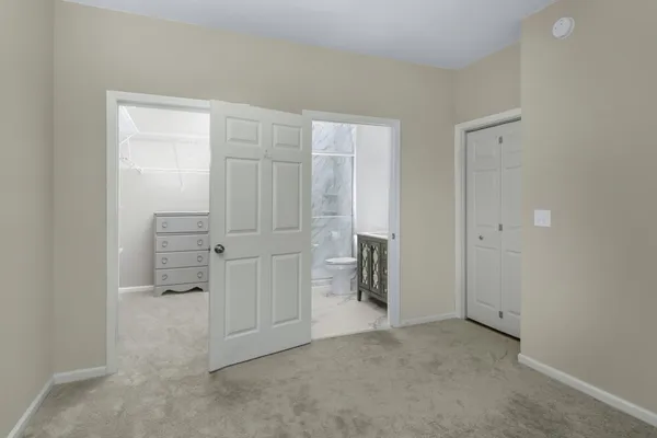 an empty room with cabinet and mirrors