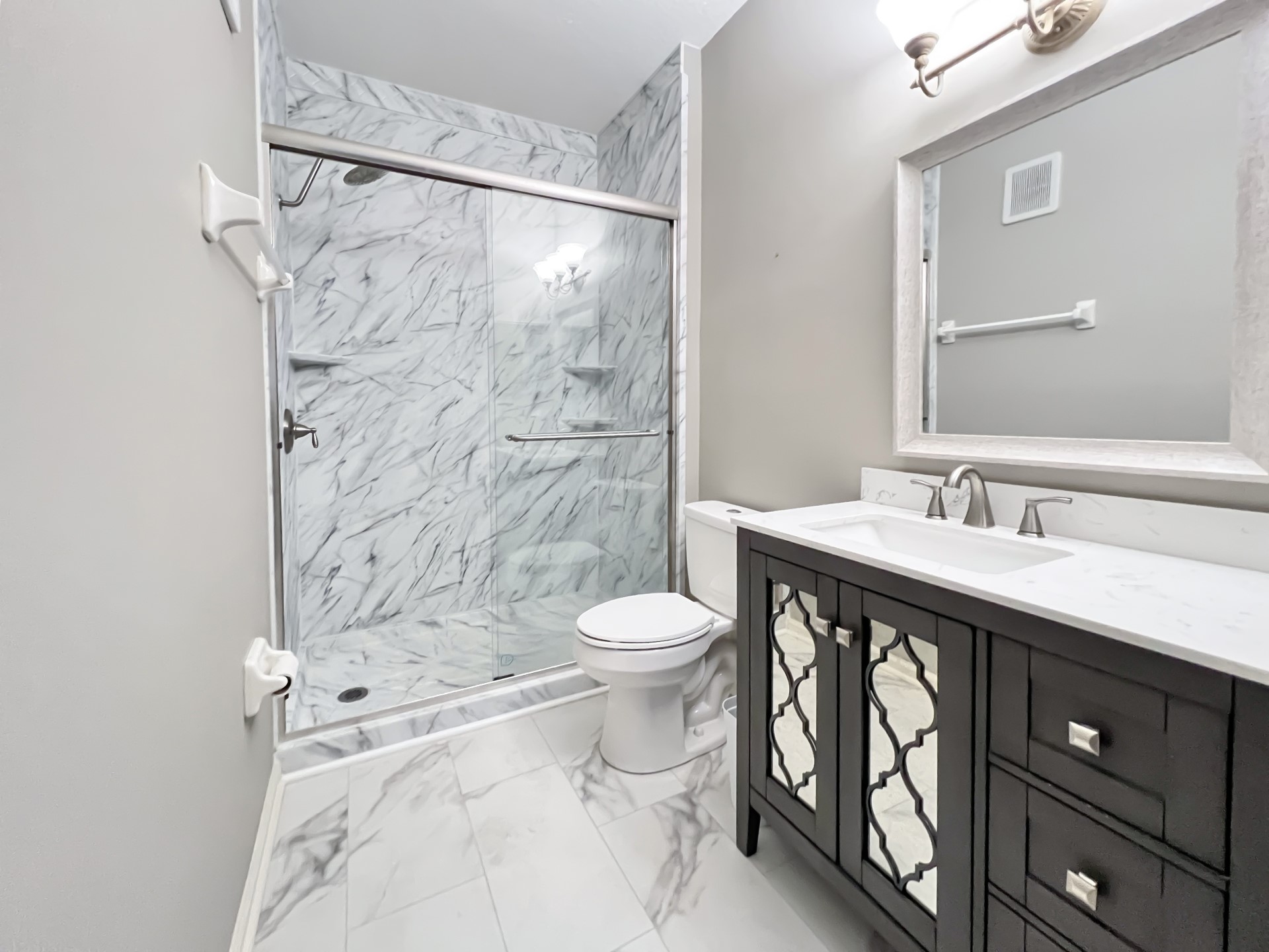 1601 Nectarine Street, Unit B2 Fernandina Beach, FL 32034 - Photo 25 of 46 a bathroom with a granite countertop sink toilet a shower and a mirror