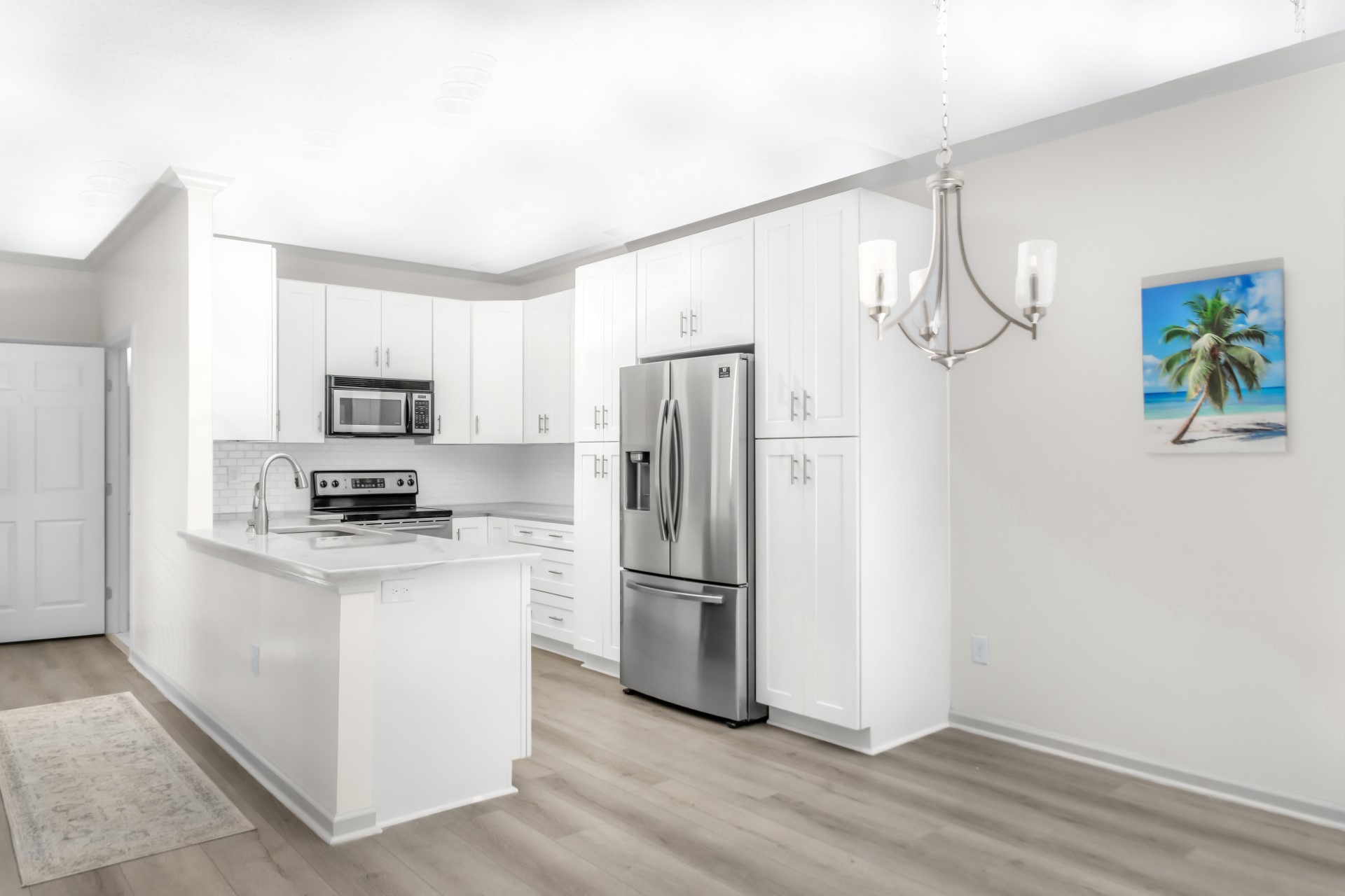 1601 Nectarine Street, Unit B2 Fernandina Beach, FL 32034 - Photo 7 of 46 a kitchen with stainless steel appliances granite countertop a refrigerator a stove a microwave and white cabinets