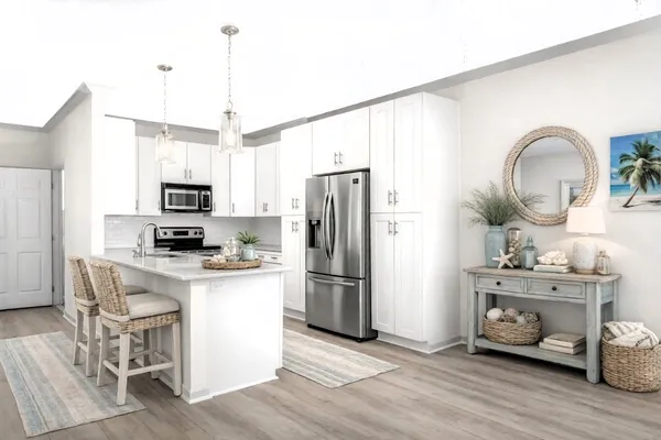 a kitchen with stainless steel appliances granite countertop a refrigerator a stove top oven a sink dishwasher and white cabinets with wooden floor