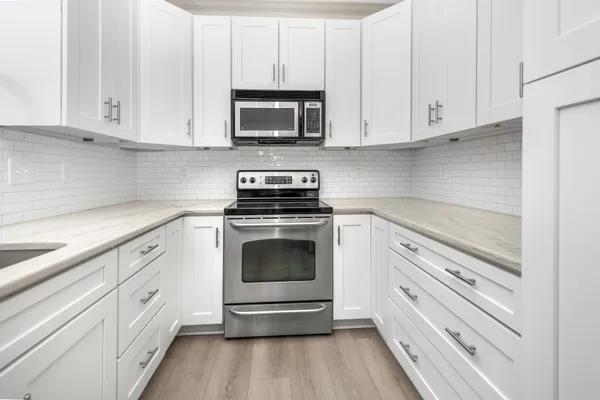 a kitchen with white cabinets stainless steel appliances and sink