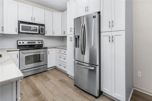a kitchen with stainless steel appliances a refrigerator stove and microwave