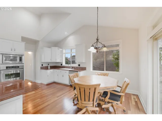 a kitchen with a dining table chairs and refrigerator