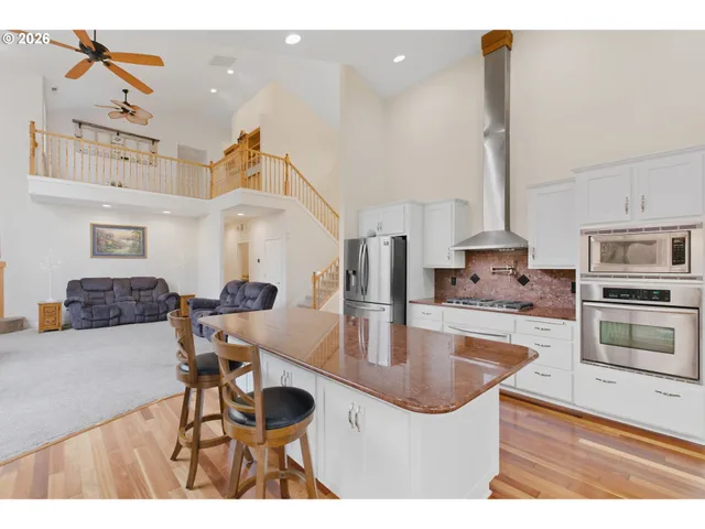 a kitchen with stainless steel appliances granite countertop a sink and a refrigerator