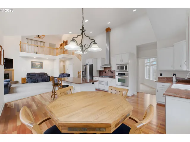 a living room with furniture a chandelier and kitchen view