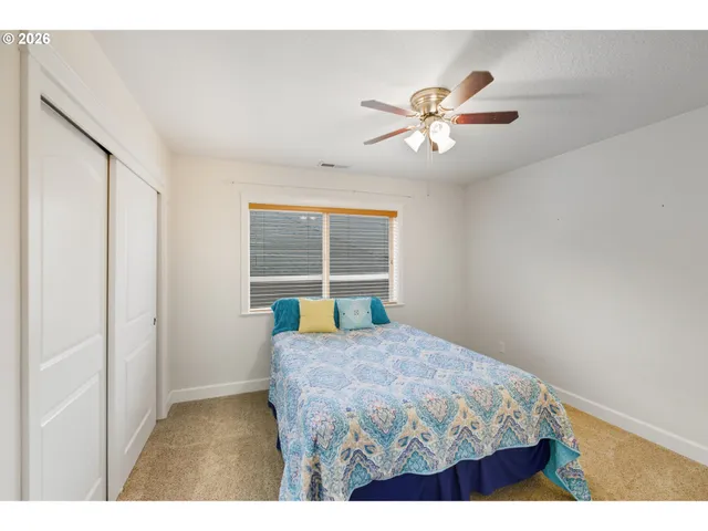a room with chandelier fan and hardwood floor