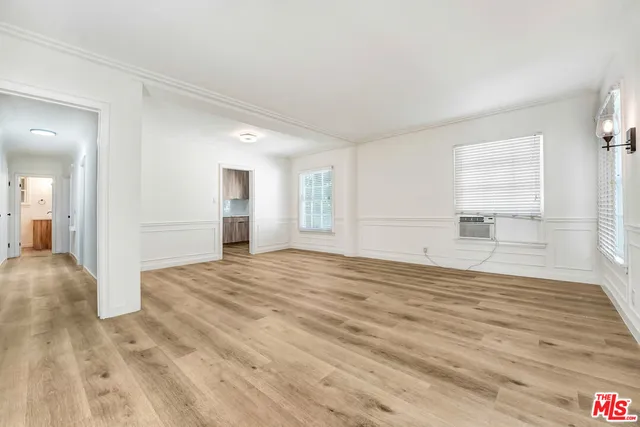 a view of empty room with wooden floor and windows