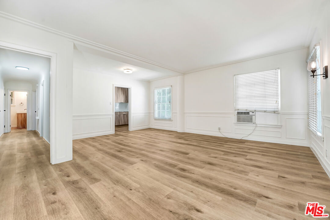 a view of empty room with wooden floor and windows