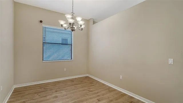 an empty room with wooden floor and a window