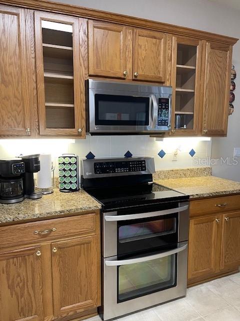 4493 Southwest 102nd Lane Road Ocala, FL 34476 - Photo 32 of 63 a kitchen with granite countertop a stove and a sink