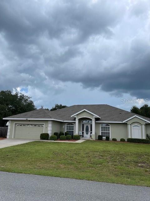4493 Southwest 102nd Lane Road Ocala, FL 34476 - Photo 6 of 63 a front view of a house with a garden