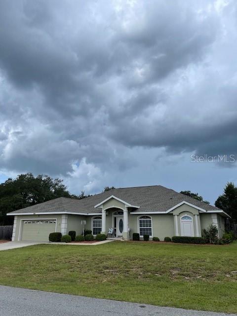 4493 Southwest 102nd Lane Road Ocala, FL 34476 - Photo 63 of 63 a front view of a house with a garden and yard