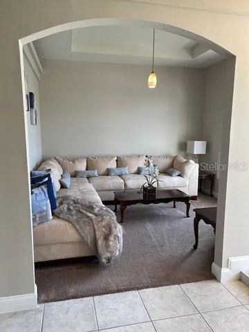 a living room with couches and large window with exposed radiator