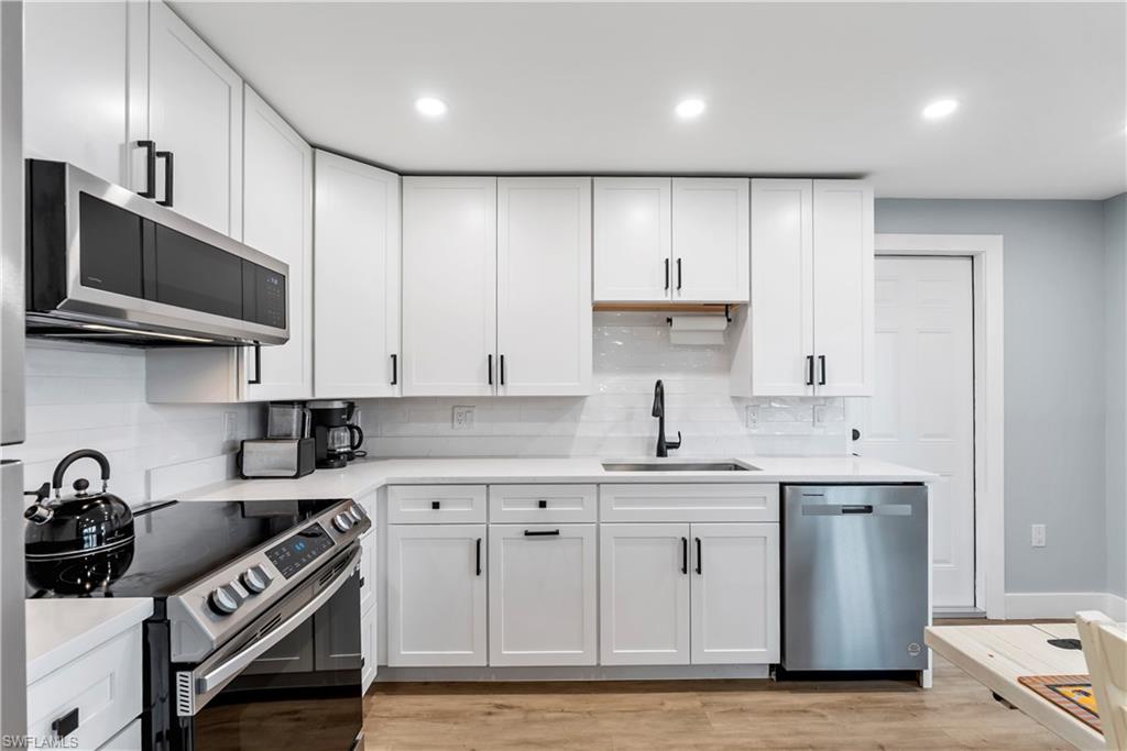 541 94th Avenue North Naples, FL 34108 - Photo 4 of 21 a kitchen with stainless steel appliances granite countertop a sink a stove and cabinets
