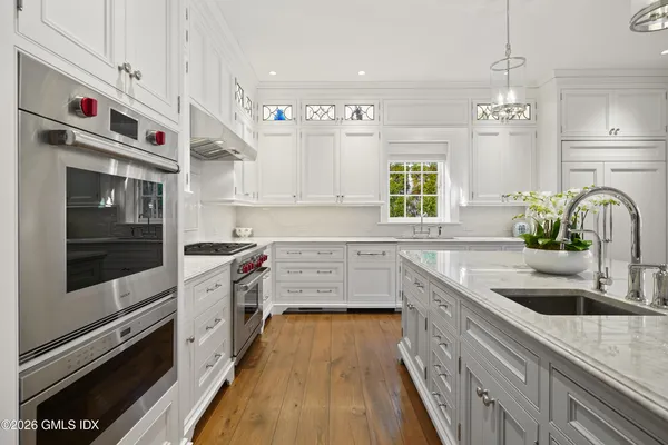 a kitchen with stainless steel appliances kitchen island granite countertop a sink and a stove