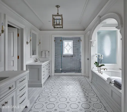 a spacious bathroom with a double vanity sink a mirror and a bathtub