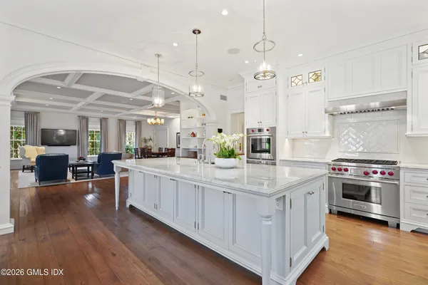 a kitchen with stainless steel appliances granite countertop a lot of counter space and wooden floors