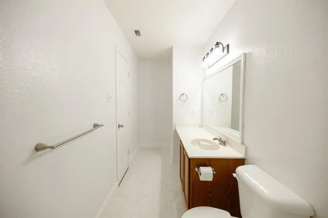 a bathroom with a sink mirror toilet and vanity