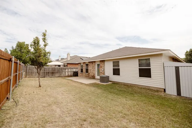 a backyard of a house with table and chairs