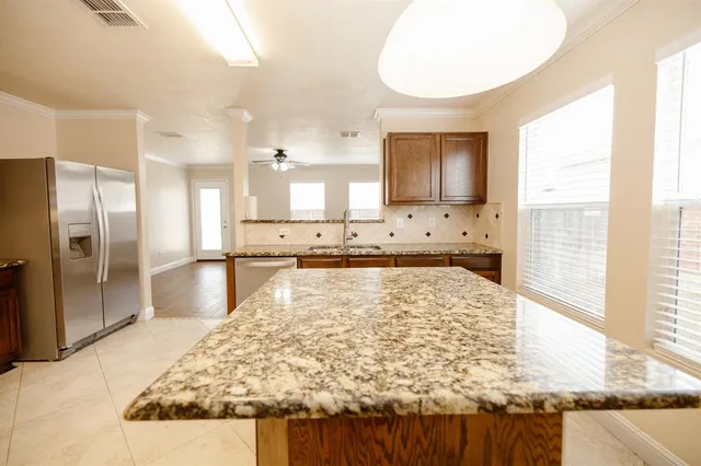 a large kitchen with kitchen island a stove a refrigerator and a sink
