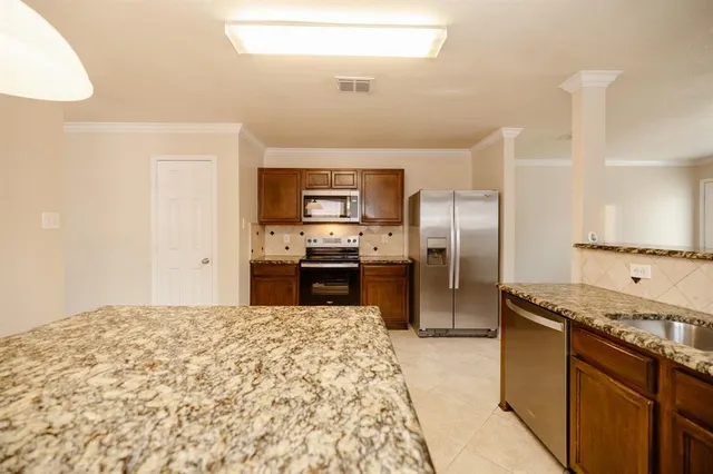 a kitchen with granite countertop a refrigerator and a sink
