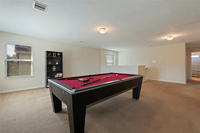 a room with pool table and windows